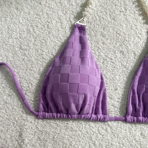 Detailed close-up of lavender checkerboard bikini top with pearl strap accents
