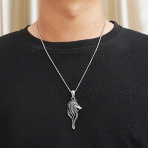 Detailed close-up of a vintage silver Viking wolf head pendant worn by a male model