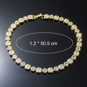 Detail of 12mm golden hip hop chain with square zircons on reflective black background