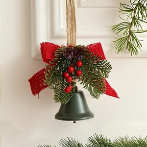 Detail of Christmas bell ornament with red burlap bow, pine cones, and frosted pine needles