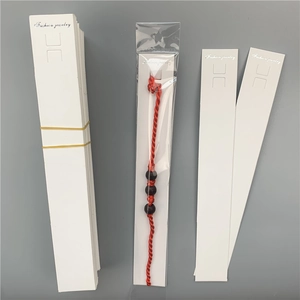 Red braided bracelet with black beads on a white Fashion Jewelry display card