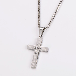 Close-up of silver double-layered cross pendant necklace with Spanish scripture engraving