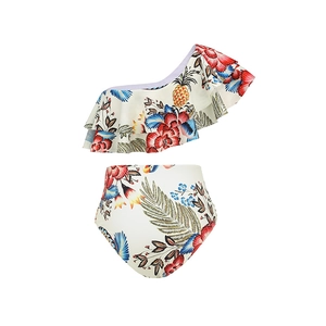 Detail of floral one-shoulder ruffle bikini top and high waist bottom with pineapple print
