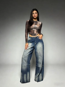 Makrodetail einer High-Waist-Jeans mit weitem Bein, Vintage-Waschung und Distressed-Textur