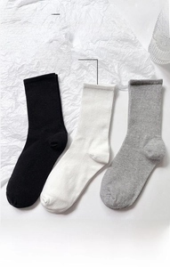 Three-pack of mid-calf cotton socks in black, white, and grey with ribbed elastic cuffs