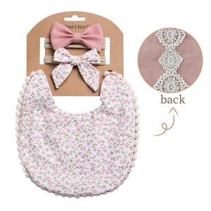Detail of floral baby bib and bow headbands with back lace stitching and pom pom trim