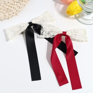 Detailed macro view of delicate floral lace and satin ribbons on bow hair clips
