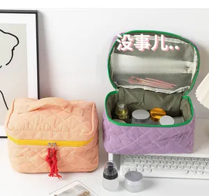 Quilted cotton travel bag with top handle and internal mesh pocket for toiletries