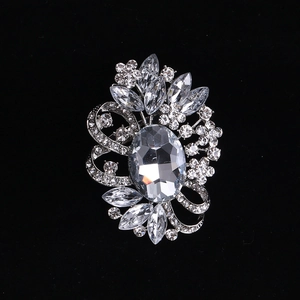 Detail of vintage silver crystal brooch with a large oval stone and floral ribbon design
