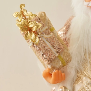 Standing Rose Gold Santa Clause doll ornament holding gift box and festive leaves