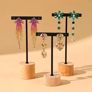 Three pairs of elegant crystal dangle earrings on black T-bar stands with wooden bases