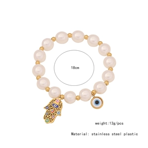Detail view of Evil Eye and Hamsa charm bracelet with white beads and metal dimensions