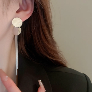 Orecchini a frange argentate con paillettes metalliche indossati di profilo laterale