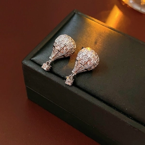 Gros plan détaillé de boucles d'oreilles montgolfière en métal argenté et zircon