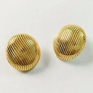 Detailed macro view of 18K gold plated ribbed geometric dome earrings with polished texture