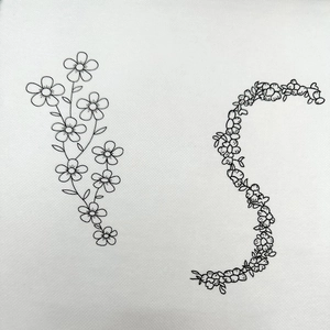 Detail of bohemian floral patterns and S-shaped embroidery stabilizer on white fabric