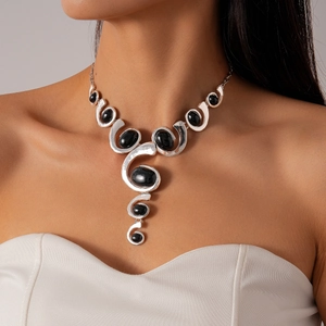 Detail of silver irregular geometric necklace with black oval gemstones on a model