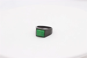 Detail of square green gemstone inlay on matte black stainless steel vintage ring