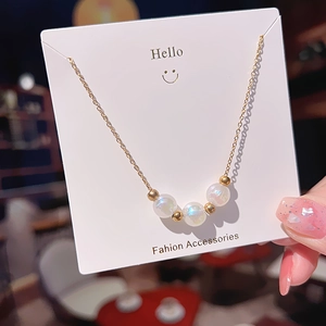 Elegant gold titanium necklace featuring three iridescent pearls on a delicate link chain