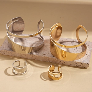 Irregular metal jewelry set featuring open bangle and matching ring in gold and silver