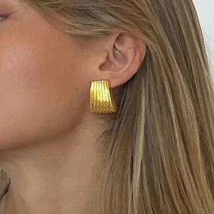 Elegante 18K Gold Edelstahl-Ohrringe mit geometrischer Wellenstruktur am Modell