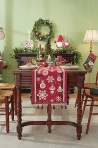 Detail of red Christmas table runner with white snowflakes and festive tassel accents