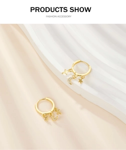 Detailed view of S925 silver gold hoop earrings with star, moon, and cross charms