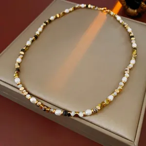 Minimalist freshwater pearl necklace with gold metal spacers on leather jewelry box