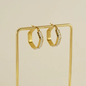 Elegant gold geometric hexagonal earrings with diamonds on a minimalist beige background