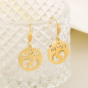 Close-up of gold stainless steel MOM earrings with heart and baby footprint cutouts