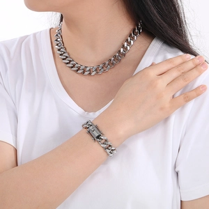 Close-up of silver Cuban link necklace and bracelet set with box clasp on model