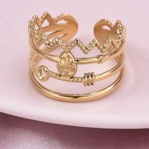 Detail of adjustable gold layered ring with crown shape and key charm on pink silk