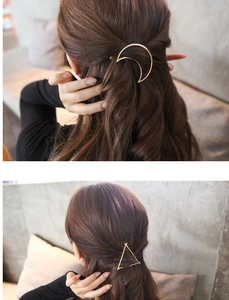 Detail view of minimalist gold geometric hair clips in moon and triangle shapes for hair styling