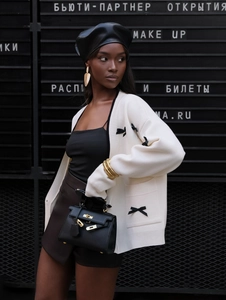 Cardigan chic in maglia bianca con fiocchi neri e scollo a V per un look autunnale
