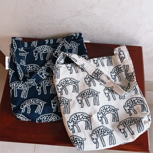 Detailed texture of cotton canvas tote bags with sheep prints and side brand labels