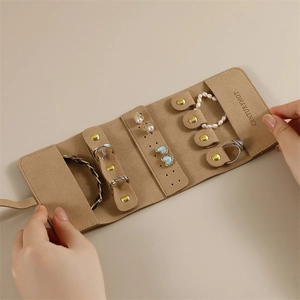 Detail view of khaki suede jewelry roll interior with ring bar and earring holders