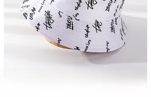 Detail of white cotton bucket hat with black graffiti print and stitch work on brim