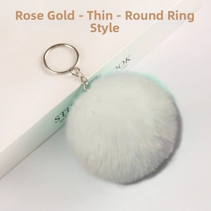 Close-up of fluffy rose gold faux fur pompom keychain with silver metal ring and chain