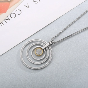 Detail of silver and gold concentric circles pendant with sparkling crystal inlay