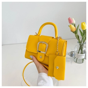 Close-up of a yellow lychee texture crossbody bag with silver buckle and coin purse