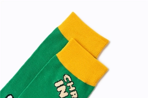 Detailed close-up showing the yellow ribbed cuff and green knit cotton texture of the sock