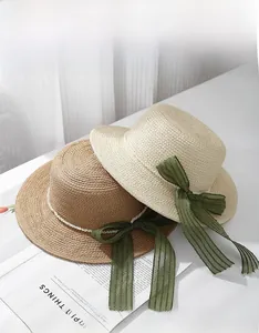 Flat top straw sun hats with green striped ribbons and pearl beads for summer vacation