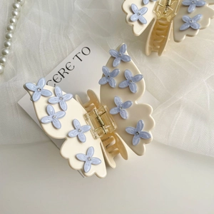 Close-up of butterfly hair claw with pale blue floral details and sparkling rhinestones