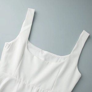 Détail du col carré et de la taille plissée d'une robe blanche d'été sans manches