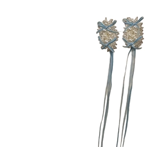 Élégantes boucles d'oreilles longues en perles avec nœuds en ruban bleu clair sur fond blanc