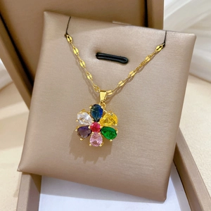 Macro shot of colorful teardrop zircon flower pendant on a golden chain necklace