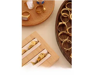 Close-up of assorted vintage gold rings with shell inlay and daisy elements on wood display