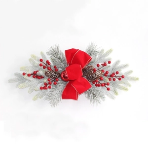Guirlande de Noël avec nœud rouge, pommes de pin et aiguilles de pin enneigées pour maison