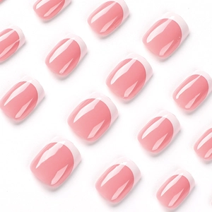Glossy pink French tip press-on nails with white edges in an organized array display