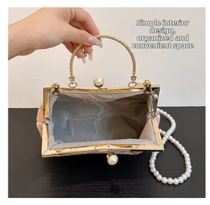 Detail view of the pink floral evening bag showing inner pocket and pearl strap